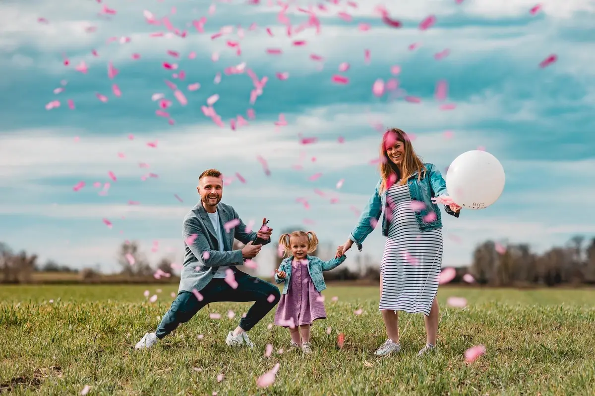 Familie feiert gemeinsam mit rosa Konfetti